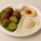 Falafel platter with hummus, fresh salad, olives, pickles, and warm pita bread at Pita Plus Grill St. Louis